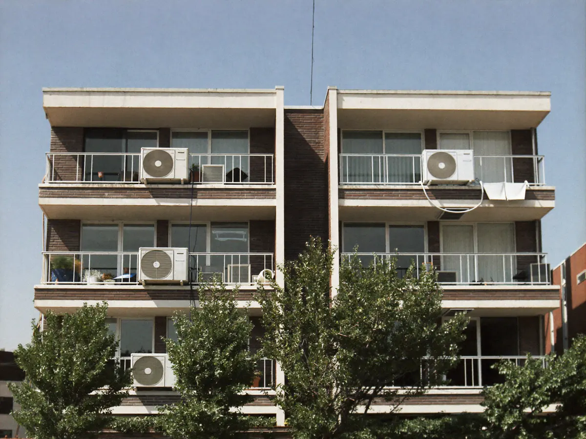 Appartementengebouw uit de jaren zeventig met buitenunits op enkele balkons